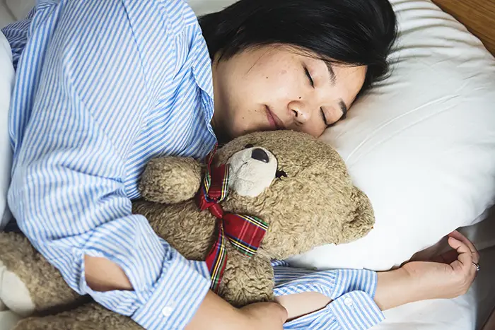 Femme dormant avec un ours