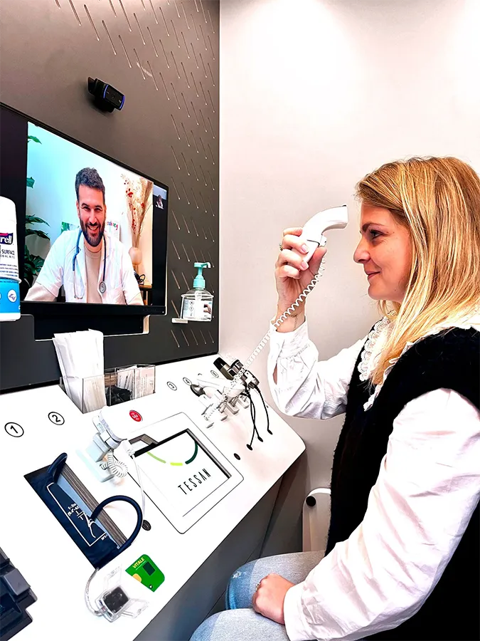 Femme dans une cabine de téléconsultation médicale 